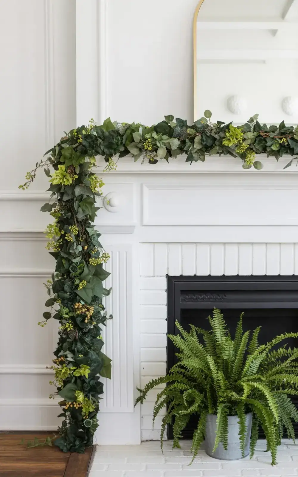 Greenery fireplace mantle and garland decor, with potted ferns.